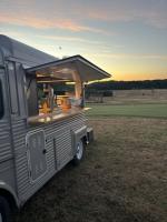 un camion-restaurant argenté garé dans un champ dans l'établissement Cottages du Golf Fleuray-Amboise, à Cangey
