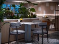 a counter with two chairs and a table with plants at Holiday Inn Yiwu Center by IHG in Yiwu