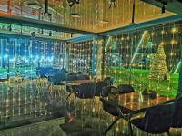 un restaurante con mesas y un árbol de Navidad en la pared en Park Hotel Chalet, en Surami