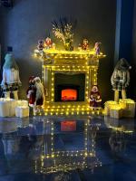 Una exhibición navideña con una chimenea con luces. en Park Hotel Chalet, en Surami