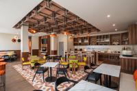 een restaurant met tafels en stoelen en een bar bij Hyatt Place Merida/ Via Montejo in Mérida