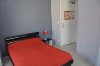 a bedroom with a red bed and a door at Hôtel Restaurant Le Bellevue in Ax-les-Thermes