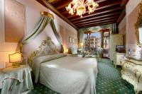 a bedroom with a white bed and a chandelier at Hotel Rialto in Venice