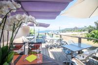 een balkon met tafels en stoelen en uitzicht op het strand bij camping la vallée in Coti-Chiavari