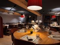 Un comedor con una gran mesa y sillas de madera. en Hôtel Alparena & Spa - 4 étoiles, en La Rosière
