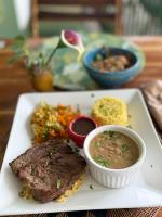 Een bord met eten, zoals vlees en soep, op tafel. bij CACTUS CLUB - Hotel, Wellness Center & Spa in São Miguel do Gostoso