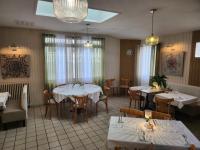 Un restaurante con mesas y sillas con manteles blancos. en Hôtel et Restaurant Les2M, en Fontenay-le-Comte