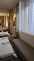 Un restaurante con mesas y sillas y una ventana. en Hôtel et Restaurant Les2M, en Fontenay-le-Comte