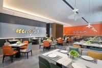 a restaurant with tables and chairs and a sign on the wall at Hampton by Hilton Cixi Guanhaiwei in Ningbo