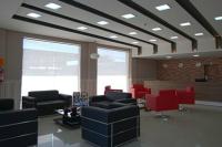 a waiting room with black chairs and red chairs at Skala Traveling Hotel in Cuiabá