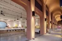 Habitación grande con columnas y mesas en un edificio en Wanda Yi, Suite Xishuangbanna, en Jinghong