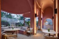 un patio con mesas y sillas y un sofá en Wanda Yi, Suite Xishuangbanna, en Jinghong