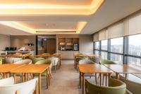 Un restaurante con mesas, sillas y ventanas. en 先泽酒店, en Huadu