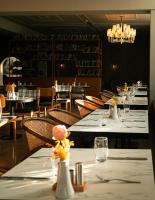 Un comedor con mesas y sillas blancas. en Le Royal Plaza, en Kenitra