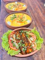 three plates of food on a wooden table at Pousada Al Mare Beach in Luis Correia