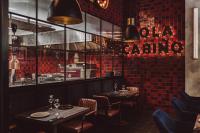 un restaurant avec deux tables et un mur carrelé de rouge dans l'établissement Apartamenty Lighthouse - Premium Porto Nadmorskie Tarasy, à Kołobrzeg