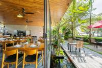 ein Restaurant mit Tischen und Stühlen und einem Teich in der Unterkunft Gia Huy Riverside Hotel Hoi An in Hoi An