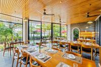 ein Restaurant mit Holzdecken und Tischen und Stühlen in der Unterkunft Gia Huy Riverside Hotel Hoi An in Hoi An
