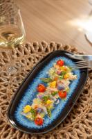 een bord eten met een vork en een glas wijn bij Ayana Coral Bay Resort in Slatina