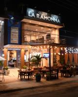 un restaurante con mesas frente a un edificio por la noche en Hotel La Ramonna Melaque, en San Patricio Melaque