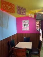 a table and chairs in a restaurant with a pink wall at Hotel Puerto México Aeropuerto in Mexico City