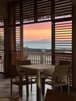 una mesa y sillas en una habitación con vistas al océano en Holiday Beach Hotel, en Nosy Be