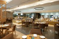 a restaurant with tables and chefs in the background at Feathers- A Radha Hotel, Chennai in Chennai