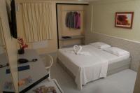 a small room with a bed and a table at JR Hotel in João Pessoa