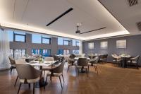 a dining room with tables and chairs and windows at Huanman Hotel Jishou State Government Branch in Ganziping