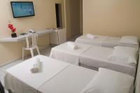 a hospital room with three beds and a tv at JR Hotel in João Pessoa