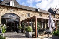 多尔德布列塔尼Mobile Homes by KelAir at Camping Domaine des Ormes的前面有一把伞的大砖砌建筑