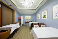 a room with two beds and a table and chairs at Chinese Culture Boutique Hotel TangFu, Liangma Riverside, Near Sanlitun & Embassy Area, Metro Access, 20min to Wangfujing, Forbidden City & Tian'anmen Square, Airport & the Great Wall Travel Assistance in Beijing