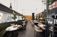 a restaurant with tables and chairs in a room at Chinese Culture Boutique Hotel TangFu, Liangma Riverside, Near Sanlitun & Embassy Area, Metro Access, 20min to Wangfujing, Forbidden City & Tian'anmen Square, Airport & the Great Wall Travel Assistance in Beijing