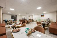 ein Esszimmer mit Tischen und Stühlen und eine Cafeteria in der Unterkunft Noida business suites 141 in Noida