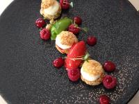 een zwart bord met een aardbei en bessen erop bij Les Chambres Lauryvan in Saint-Junien