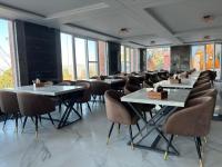 Una fila de mesas y sillas en una habitación con ventanas. en Muskan Mount View Retreat, Mukteshwar, en Mukteshwar