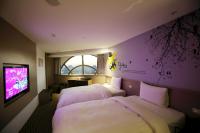a hotel room with two beds and a tv at Chiayi Look Hotel in Chiayi City