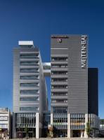 Un edificio alto con un cartel encima. en Hotel Sunroute Tokushima, en Tokushima