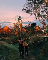 een vrouw en een kind lopen voor een resort bij Buôn Gơ Rin in Láng Lớn