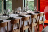 a long table with chairs and plates and wine glasses at The Dome House in Bowness-on-Windermere