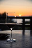 un bicchiere di vino seduto su un tavolo con il tramonto di Mounda Beach Retreat a Skala di Cefalonia