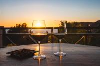 due bicchieri di vino seduti su un tavolo con il tramonto di Mounda Beach Retreat a Skala di Cefalonia