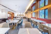 uma sala de jantar com mesas, cadeiras e janelas em Atour Hotel Wuhan Chuhehanjie Xiu Theater em Wuhan