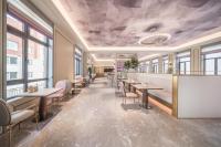 a restaurant with tables and chairs and windows at 长白山 Mercure Hotel in Baomacheng