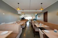 um restaurante com mesas, sofás e cadeiras em Ira by Orchid Porvorim Goa em Porvorim