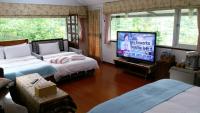 a living room with two beds and a flat screen tv at Jilufugan B&amp;B in Taimali