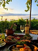 Una mesa con un plato de comida y una botella de vino. en Baias Wine, en Bagdatʼi