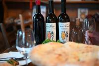 Tres botellas de vino sobre una mesa con copas de vino. en Baias Wine, en Bagdatʼi