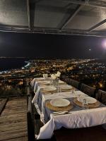 un lungo tavolo con piatti bianchi e bicchieri da vino sopra di Gokyuzu Hotel a Akcay