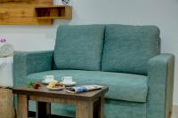 a living room with a green couch and a table at Fly Inn Bangalore Airport in Muthugadahalli